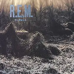 A train trestle covered in thick kudzu with "R.E.M. / MURMUR" written in blue