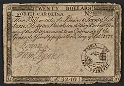 A twenty-dollar banknote issued by South Carolina in 1777 with the inscription: "SOUTH CAROLINA. This Bill intitles the Bearer to Twenty Dollars or Thirty two Pounds ten shillings Current Money of this State pursuant to an Ordinance of the General Assembly passed the 14th Day of Feb. 1777." ; Denominations stated as: "TWENTY DOLLARS" and "L32.10". ; Within emblem: "UBI LIBERTAS IBI PATRIA" ; Verso: "XX Dollars. DEATH TO COUNTERFEIT. L. 32:10:0".