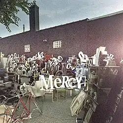 Household furniture set over a graffitied factory wall