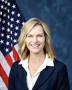 Official House portrait of Fedorchak smiling in front of the U.S. flag, wearing a black blazer jacket, white shirt, and gold dog tag necklace.