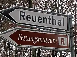 Direction signs for a minor route to a destination (white) and tourist attraction (brown) in Switzerland.