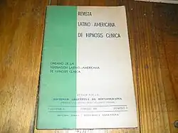 Old A4 cover of a medical journal. Turquoise green band of colour runs vertically down the left hand side, taking up about one third. The rest is off white. Faded blocky titles.