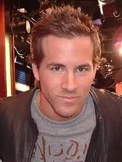 Reynolds staring towards the camera with a slight smirk on his face