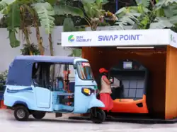 An electric rickshaw at a battery swapping point