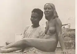 A young Sagini standing beside his statue of a nude woman