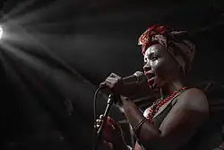 Shola Adisa-Farrar holding a microphone