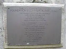 Grey plaque, screwed into wood