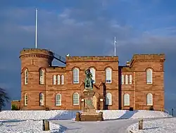 Inverness Castle in winter with the statue of Flora MacDonald in the foreground