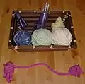 A hobbyist spool knitting machine operates on a crank.