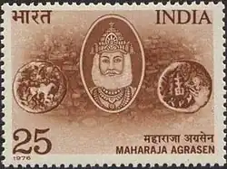 The image depicts a commemorative stamp issued by India in 1976 honoring Maharaja Agrasen. The stamp features an illustration of Maharaja Agrasen, often depicted in royal attire, emphasizing his historical significance as a revered figure in the Agrawal community. The background is typically adorned with traditional motifs, highlighting his connection to Indian culture and heritage. The stamp serves to celebrate his legacy and the values he represents, particularly in relation to the Agrawal community’s origins.