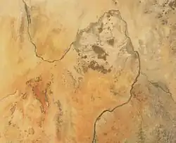 A deserted image of Sudan is depicted. The Nile River snakes in an S shape from the top of the picture to the bottom