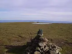 Cairn on the north top of Stybarrow Dodd incorporating the slate marker. Beyond is the intermittent pool, and the remains of the wall