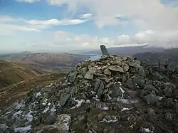 The summit cairn on Sheffield Pike, with stone boundary marker, and Ullswater beyond