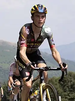 Sepp Kuss riding a bicycle during the Tour de France, wearing a jersey that reads Jumbo-Visma