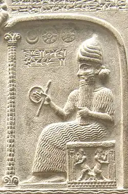 Representation of Shamash from the Tablet of Shamash (c. 888 – 855 BC), showing him sitting on his throne dispensing justice while clutching a rod-and-ring symbol