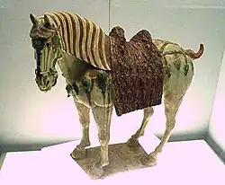 A Chinese Tang dynasty tri-color glazed porcelain horse (c. 700 AD), using yellow, green and white colors.
