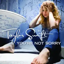 Cover art of "You're Not Sorry", showing Swift sitting on the ground against a wall, holding her head. The word "sorry" is scribbled all over the walls
