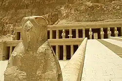 Statue of a falcon (foreground) and stone ramp (background)