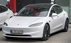 A front three-quarters view of a white 2023 facelifted Tesla Model 3