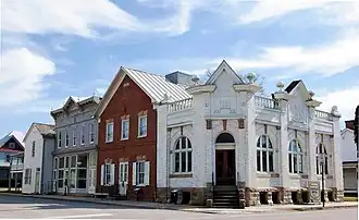 A white brick building on a street corner.