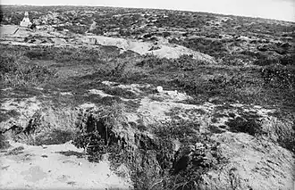 The terrain around Baby 700 as viewed from The Nek, taken after the war. There is a Turkish memorial in the distance, and sun bleached human remains in the foreground