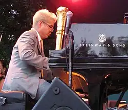 Photograph of man playing a piano