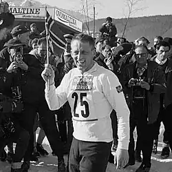 Man in skiing gear and number 25 on shirt being photographed