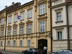 Tan, older two-story building with flag in front