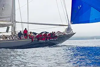 Velsheda under sail - crew are sitting on the gunwale.