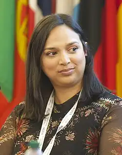 A woman shown from the neck up looks off camera