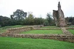 Color photograph of ruined walls on a grassy esplanade.