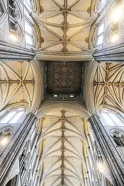 A view looking directly up at a very high, coloured, patterned ceiling.