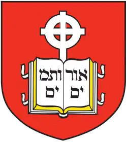 Coat of arms of the school, containing a book device inscribed with Hebrew letters and cross in front of a red background