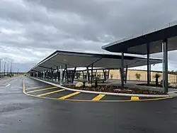 A bus interchange with shelter running the length of the interchange road