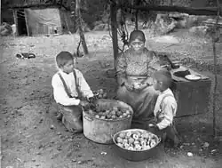 Yokuts woman and two boys preparing peaches on the Tule River Reservation ~1900AD