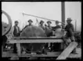 Sawmill workers posing with saw blades, Rainy River District, 1900–1909